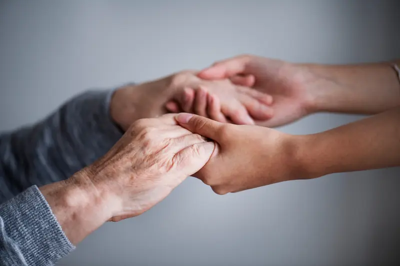 Mãos dadas em gesto de apoio e acolhimento